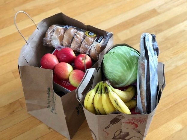 Paper bags filled with assorted groceries like fruits, vegetables, and bread