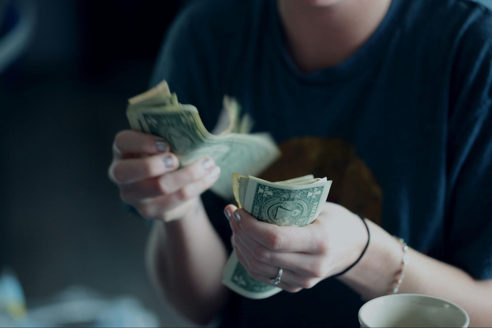 Close-up of someone holding and counting paper money.