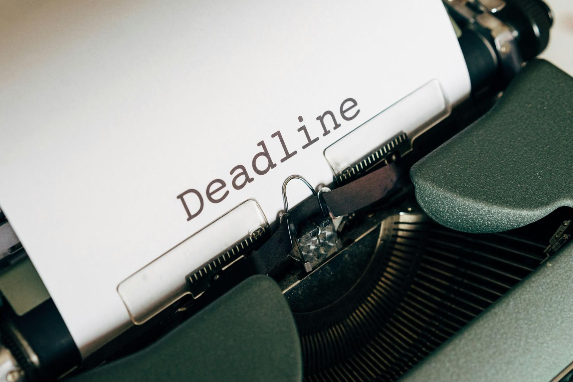 Vintage typewriter with a sheet of paper reading “Deadline”