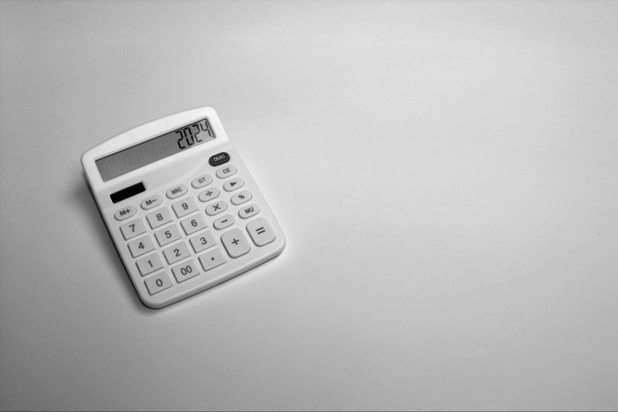 Minimalist image of a white calculator on a white surface.